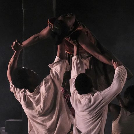 Dancers lifting another dancer into the air.