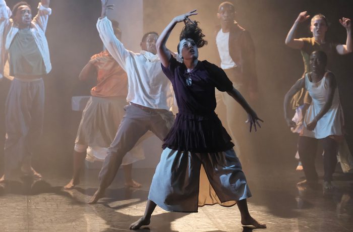 Dancers on stage under spotlights.
