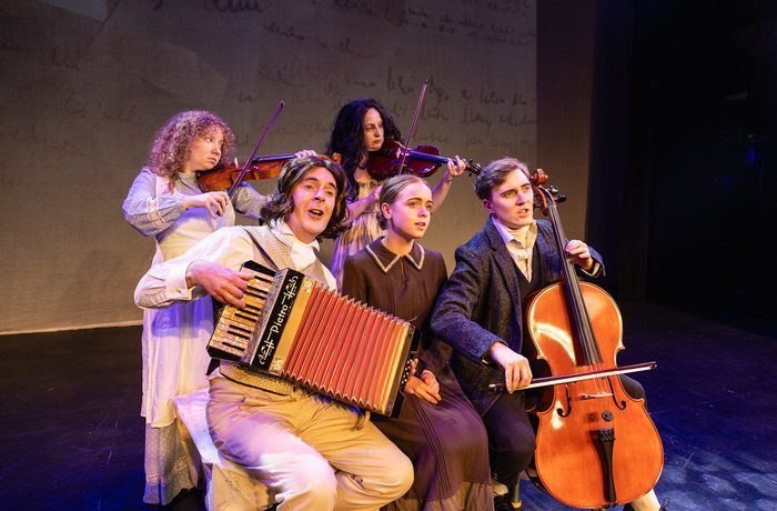 A group of people in period costume, playing musical instruments.