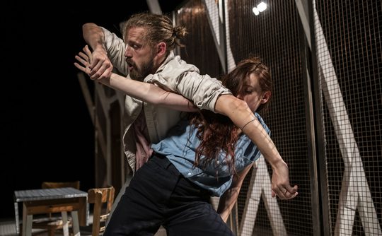 Two people with their arms and bodies tangled together.