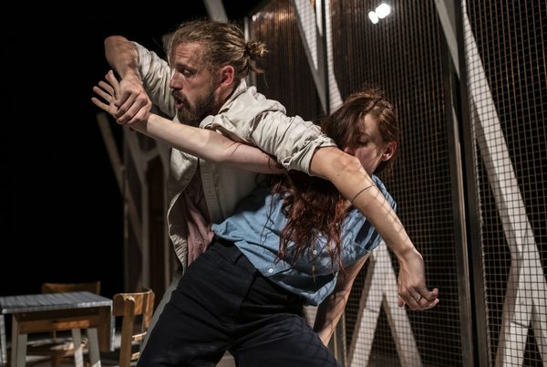 Two people with their arms and bodies tangled together.