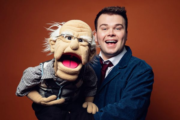 Max Fulham holding a puppet of an old man.