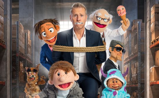 Paul Zerdin bound and gagged, and surrounded by puppets.