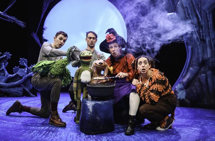 All the performers with their puppets around a smoking cauldron.