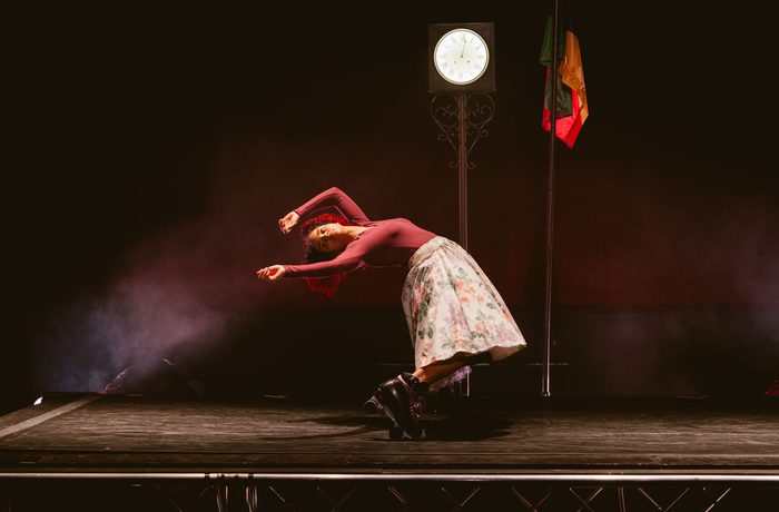 A person on a stage, bending over backwards.