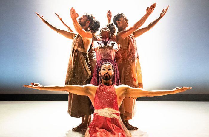 Dancers posing with their arms out.