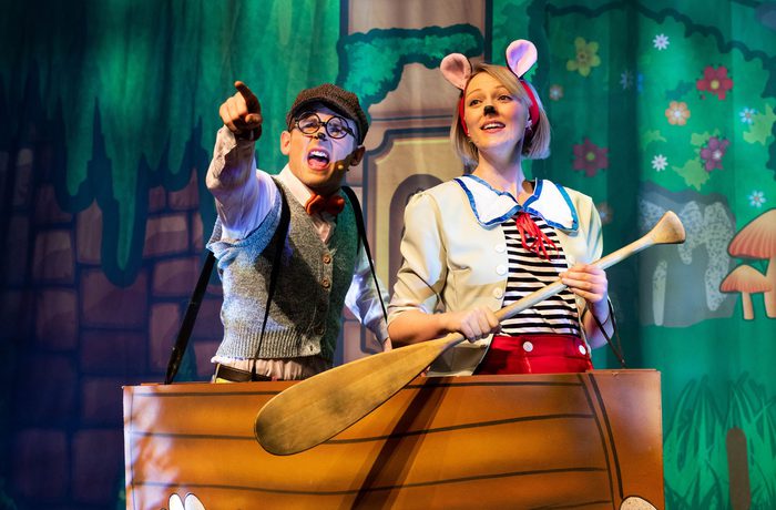 Two performers on stage in a rowing boat