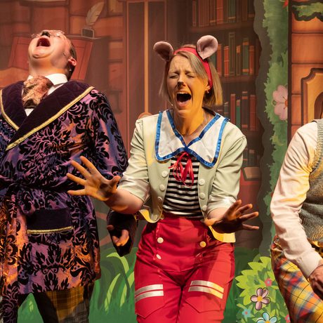 Three performers laughing histerically