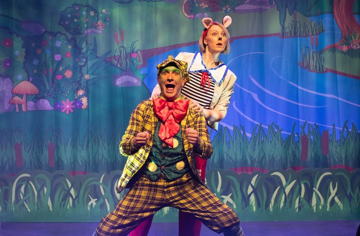 Two performers looking out into the audience - one jump on the other.