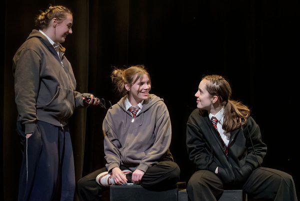 Youth theatre members performing on a stage.
