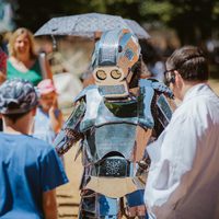 A person dressed as a robot, talking to two other people.