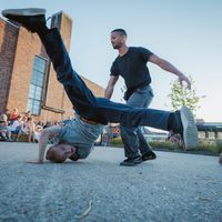 Two people breakdancing in the street.