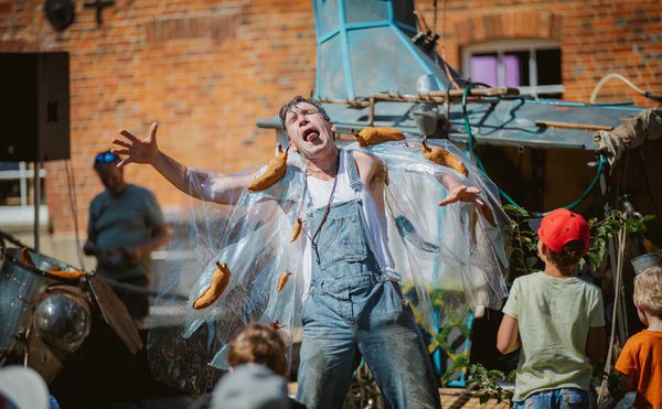 A person covered in giant slug puppets.