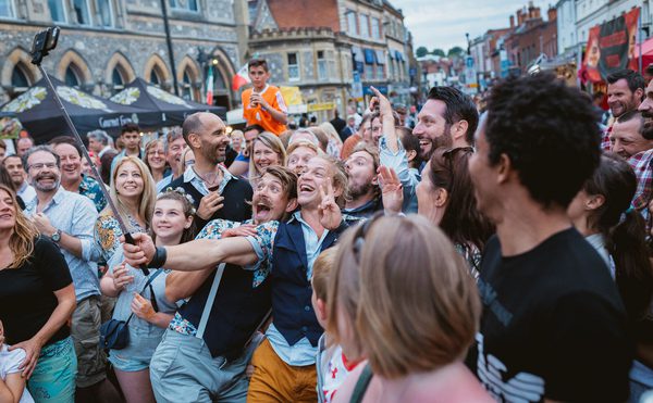 A large crowd of people posing for a photo on the streets of Winchester