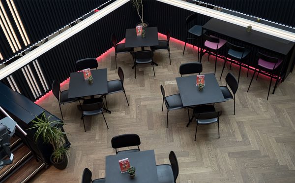 A view of the Atrium at Theatre Royal Winchester from above. Tables and chairs.