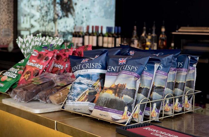 A selection of sweets, crisps and snacks on a bar.