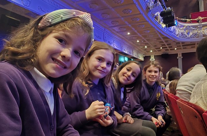 Young people looking happy in the theatre watching a show.
