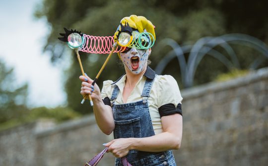 Hat Fair performer, googly eyes, denim dungarees