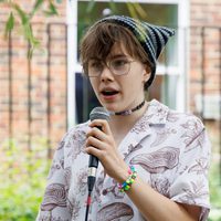 A young person holding a mic outdoors.