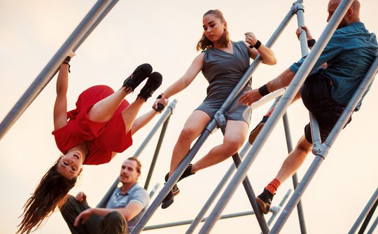 Four acrobats performing on scaffolding poles.