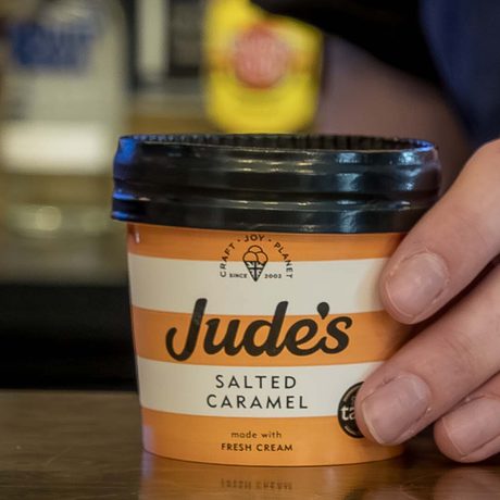 A hand holding a Jude's salted caramel ice cream.