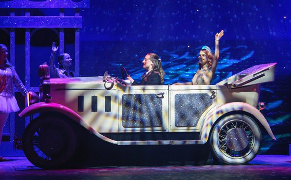 Cinderella in a car waving, on stage.