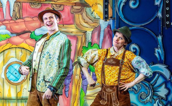Two panto performers on set posing with silly faces.