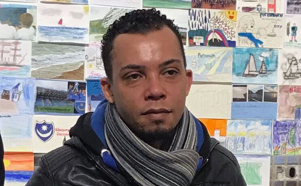 Majid Dhana, Board Member, dark coat, striped scarf