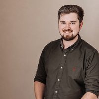 A person with a beard and shirt smiling.