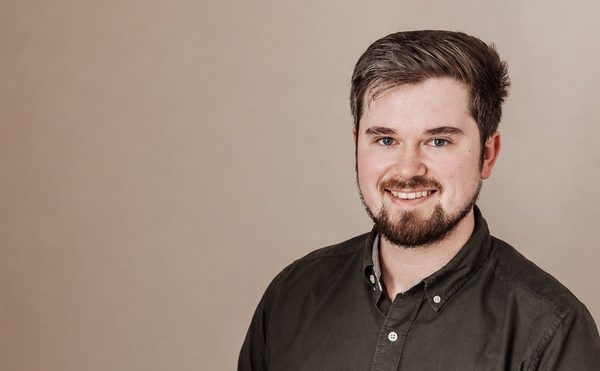 A person with a beard and shirt smiling.